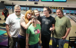 A group of six people, including the author and her husband, standing in front of bowling lanes at a bowl-a-thon.