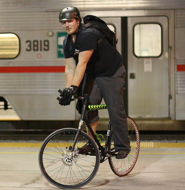 Guy on a bike by a train