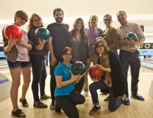 A group of 9 people holding bowling balls at an abortion fundraising event.