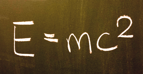 The equation E=mc2 written with chalk on a blackboard.