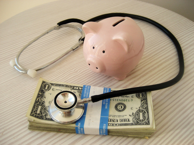 stethoscope on money with piggy bank
