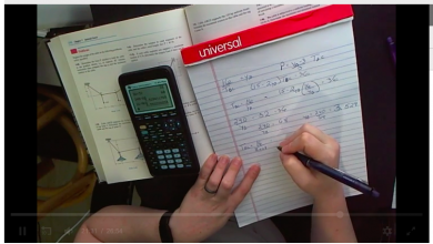 screenshot of a problem solving video showing hands writing on paper
