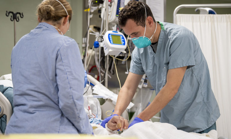 two healthcare professionals at a hospital treating a patient