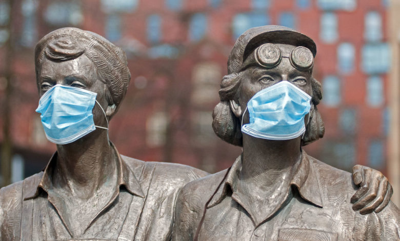 a statue of two women with blue masks over their faces