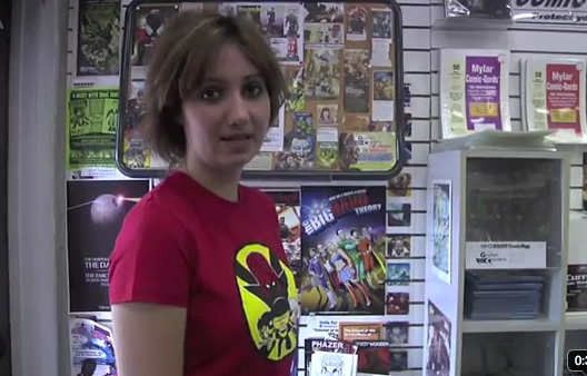 Young woman in a comic book shop facing the camera