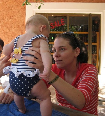 Young white woman holding up a baby