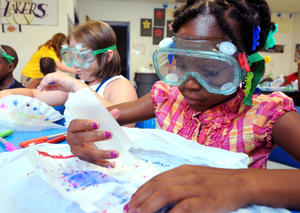 Girls working on a science project with goggles on